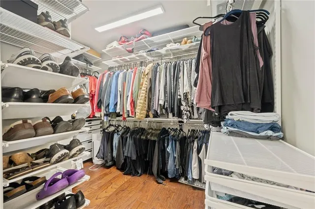 a view of walk in closet with clothes and shoes