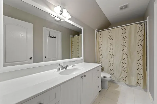 a bathroom with a double vanity sink mirror and toilet