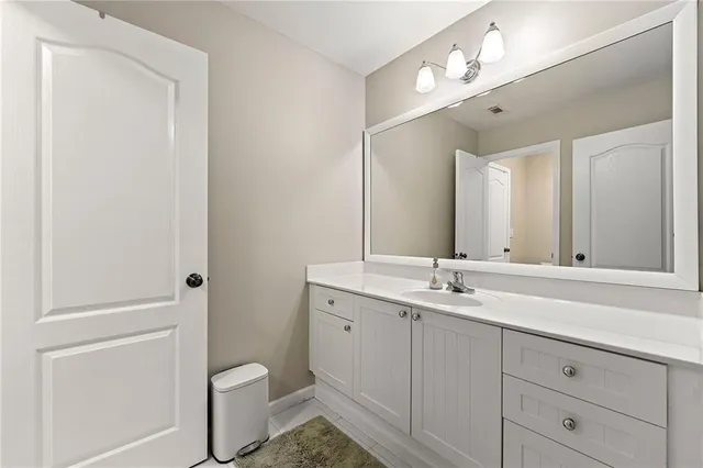 a bathroom with a granite countertop sink a toilet and a mirror