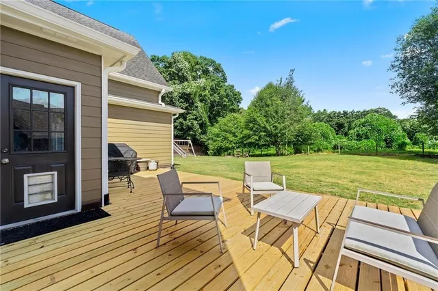 swimming view of house with yard outdoor seating and barbeque oven