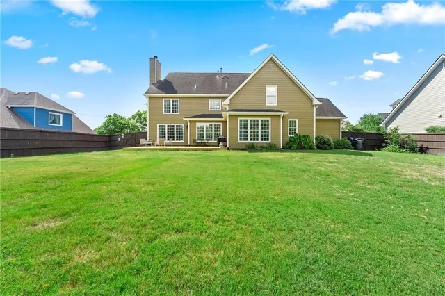 a front view of a house with a yard and trees