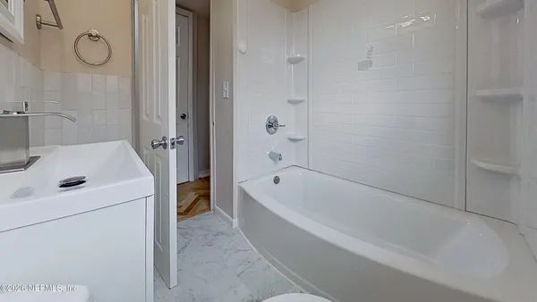 a bathroom with a tub a sink and a shower
