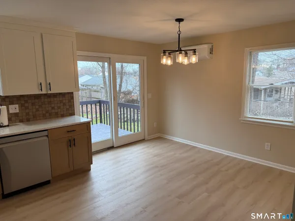 a view of a kitchen with granite countertop wooden floor a ceiling fan and windows