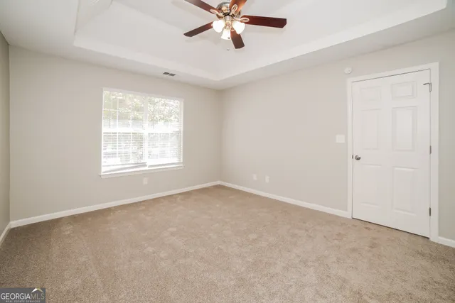 an empty room with a window and a fan