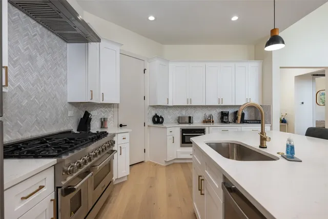 a kitchen with stainless steel appliances white cabinets and a stove