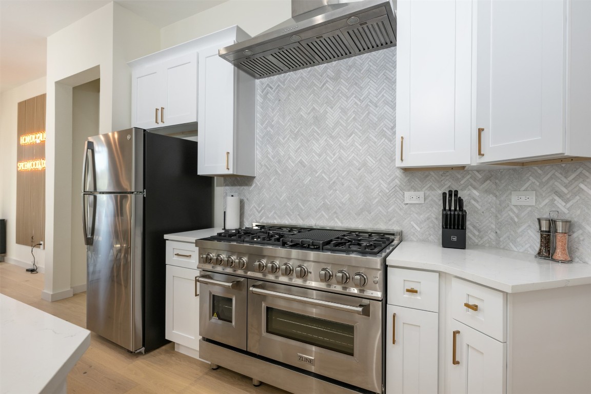 1301 Scenic Circle Spicewood, TX 78669 - Photo 14 of 39 a kitchen with stainless steel appliances white cabinets and a stove