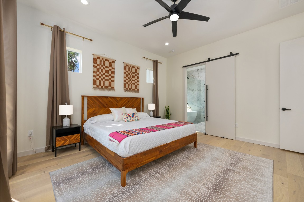 1301 Scenic Circle Spicewood, TX 78669 - Photo 22 of 39 a bedroom with a bed and a chandelier