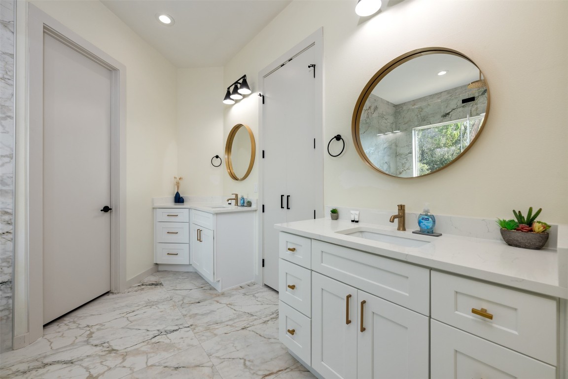 1301 Scenic Circle Spicewood, TX 78669 - Photo 24 of 39 a spacious bathroom with a double vanity sink and a mirror