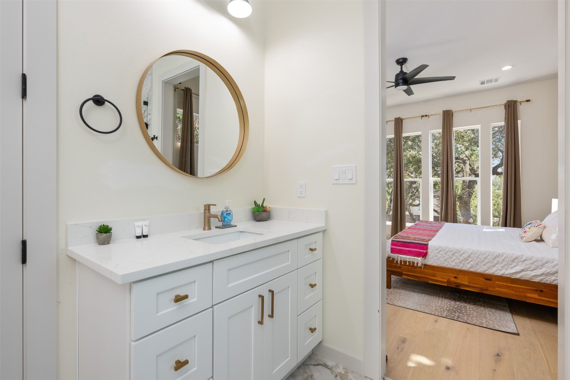 1301 Scenic Circle Spicewood, TX 78669 - Photo 28 of 39 a en suite bathroom with a sink and a mirror