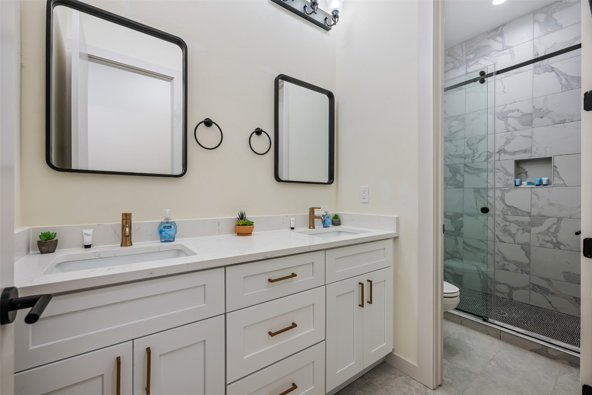 1301 Scenic Circle Spicewood, TX 78669 - Photo 32 of 39 a bathroom with a double vanity sink mirror and shower