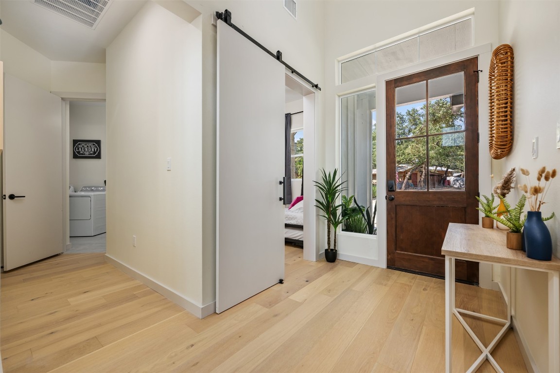 1301 Scenic Circle Spicewood, TX 78669 - Photo 4 of 39 a view of an entryway with wooden floor and a potted plant