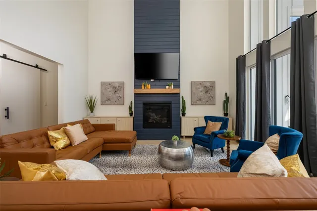 a living room with furniture a flat screen tv and a fireplace