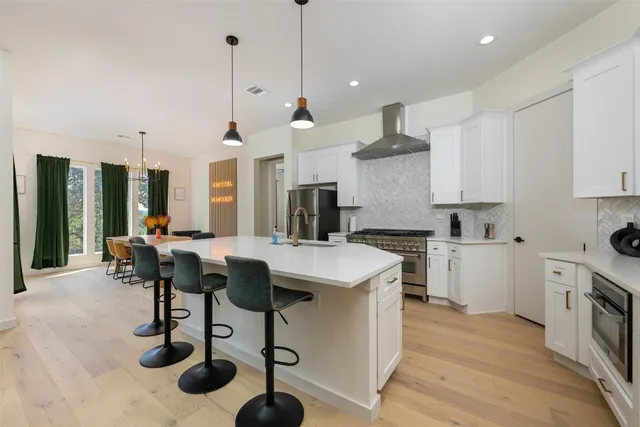 a kitchen with a table a refrigerator a cabinets and stools