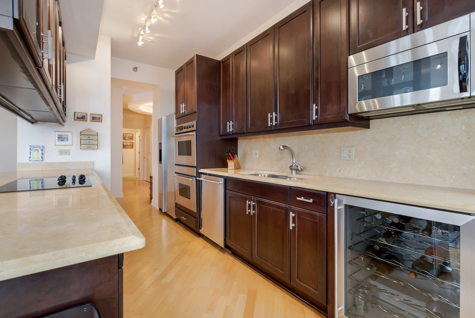 1335 South Prairie Avenue, Unit 1706 Chicago, IL 60605 - Photo 7 of 16 a kitchen with stainless steel appliances granite countertop wooden cabinets a stove top oven a sink and dishwasher