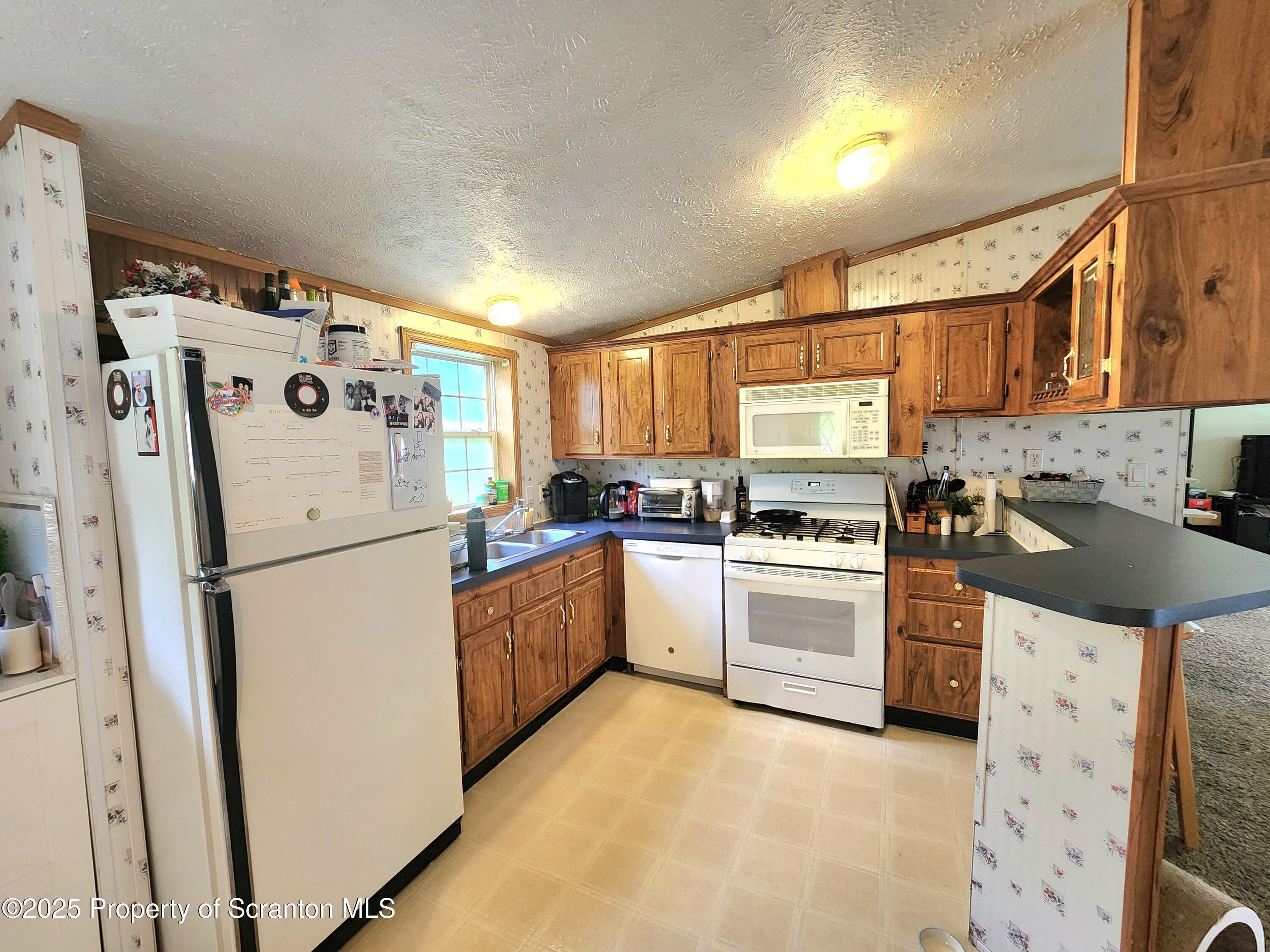 18132 Dimock To Nicholson Road Nicholson, PA 18446 - Photo 22 of 62 a kitchen with stainless steel appliances a refrigerator sink and cabinets