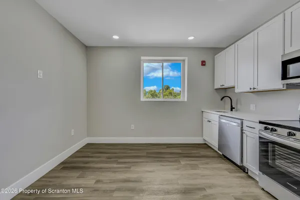a view of kitchen with wooden floor electronic appliances and window