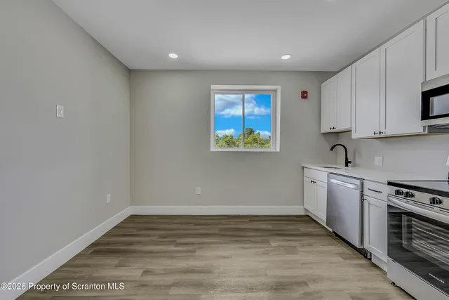 a view of kitchen with wooden floor electronic appliances and window