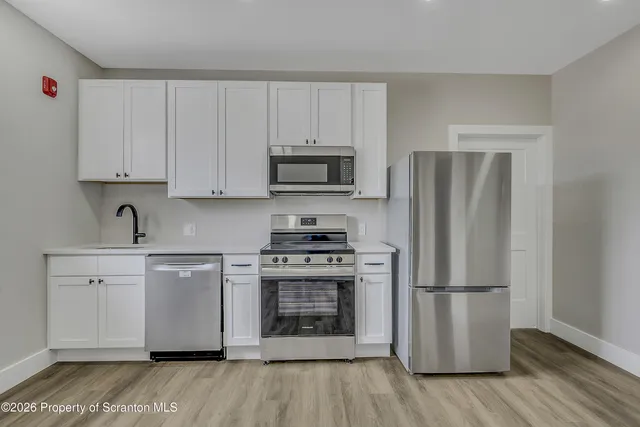 a kitchen with a refrigerator stove and wooden cabinets