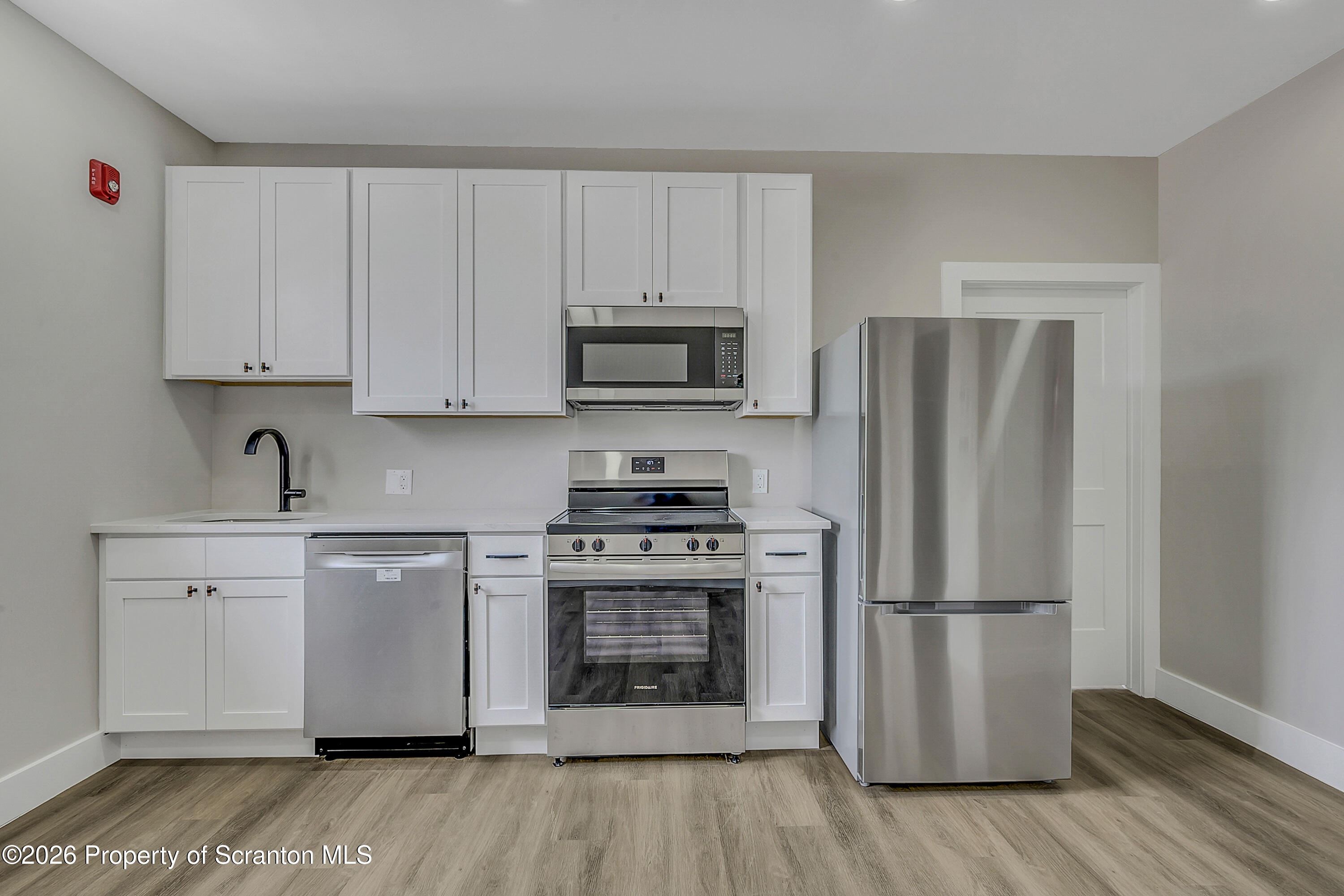 215 Hickory Street, Unit 13 Scranton, PA 18505 - Photo 12 of 13 a kitchen with a refrigerator stove and wooden cabinets
