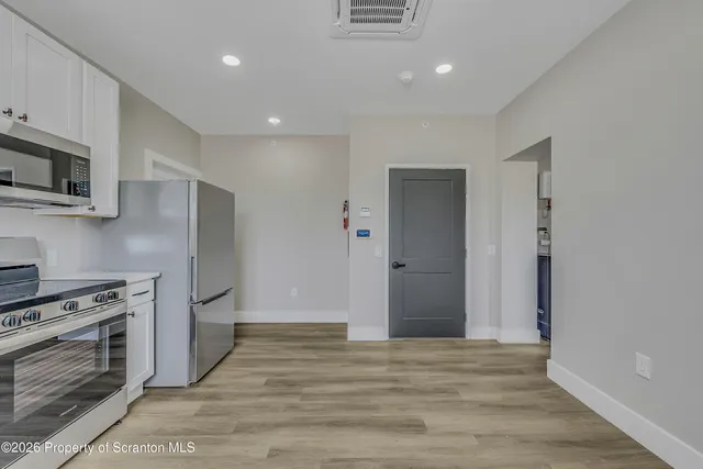a view of kitchen with wooden floor electronic appliances and window
