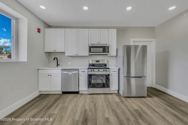 a kitchen with a refrigerator and a stove top oven
