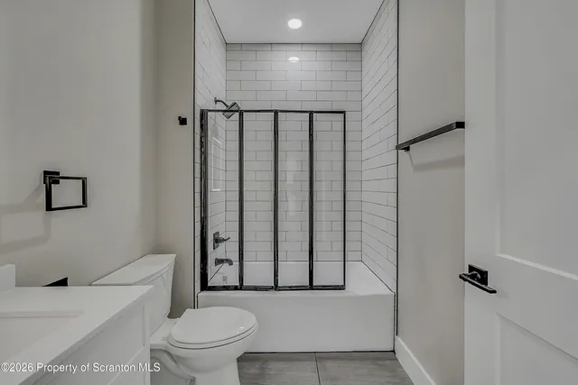 a bathroom with a toilet and a shower