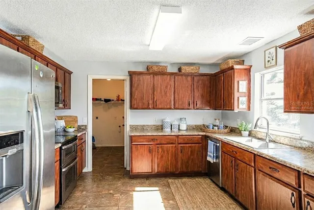 a kitchen with a sink refrigerator and cabinets