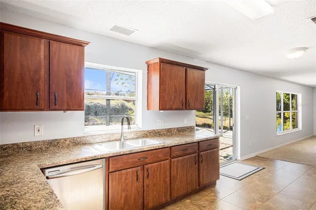 a kitchen with granite countertop a sink cabinets and window