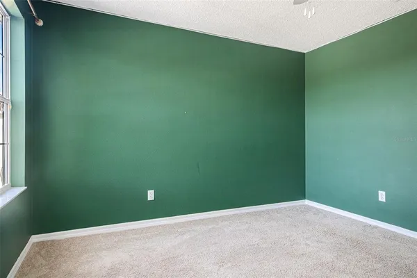 an empty room with a window and a fan