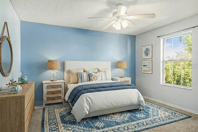 a bedroom with a bed a dresser and a chandelier