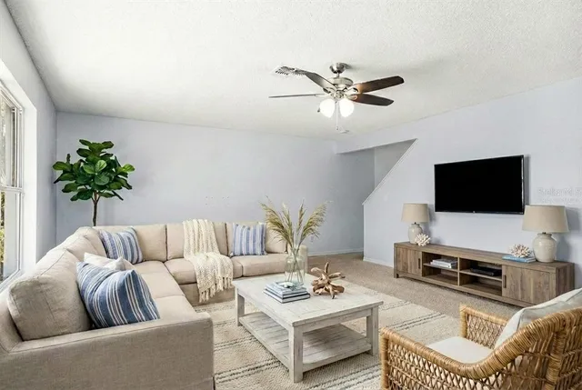 a living room with furniture a flat screen tv and a window