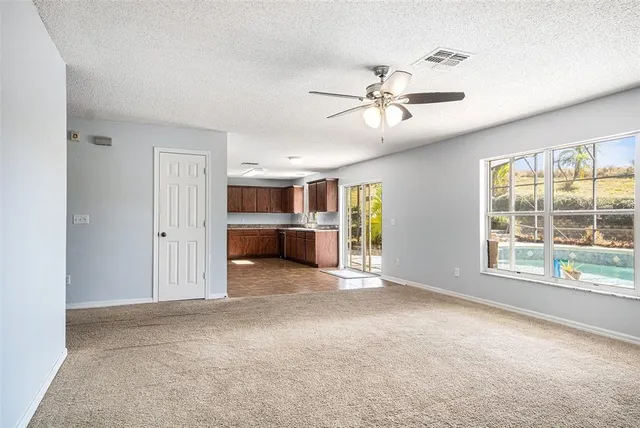 a view of a livingroom with a ceiling fan and windows