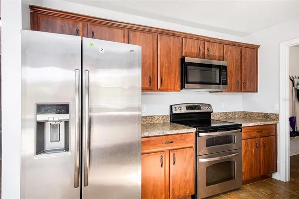 a kitchen with stainless steel appliances granite countertop a refrigerator stove and microwave