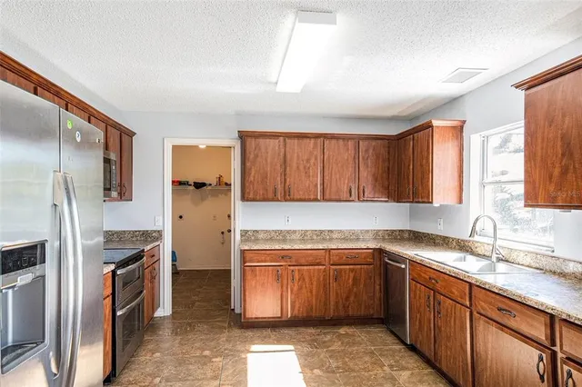 a kitchen with a sink refrigerator and cabinets