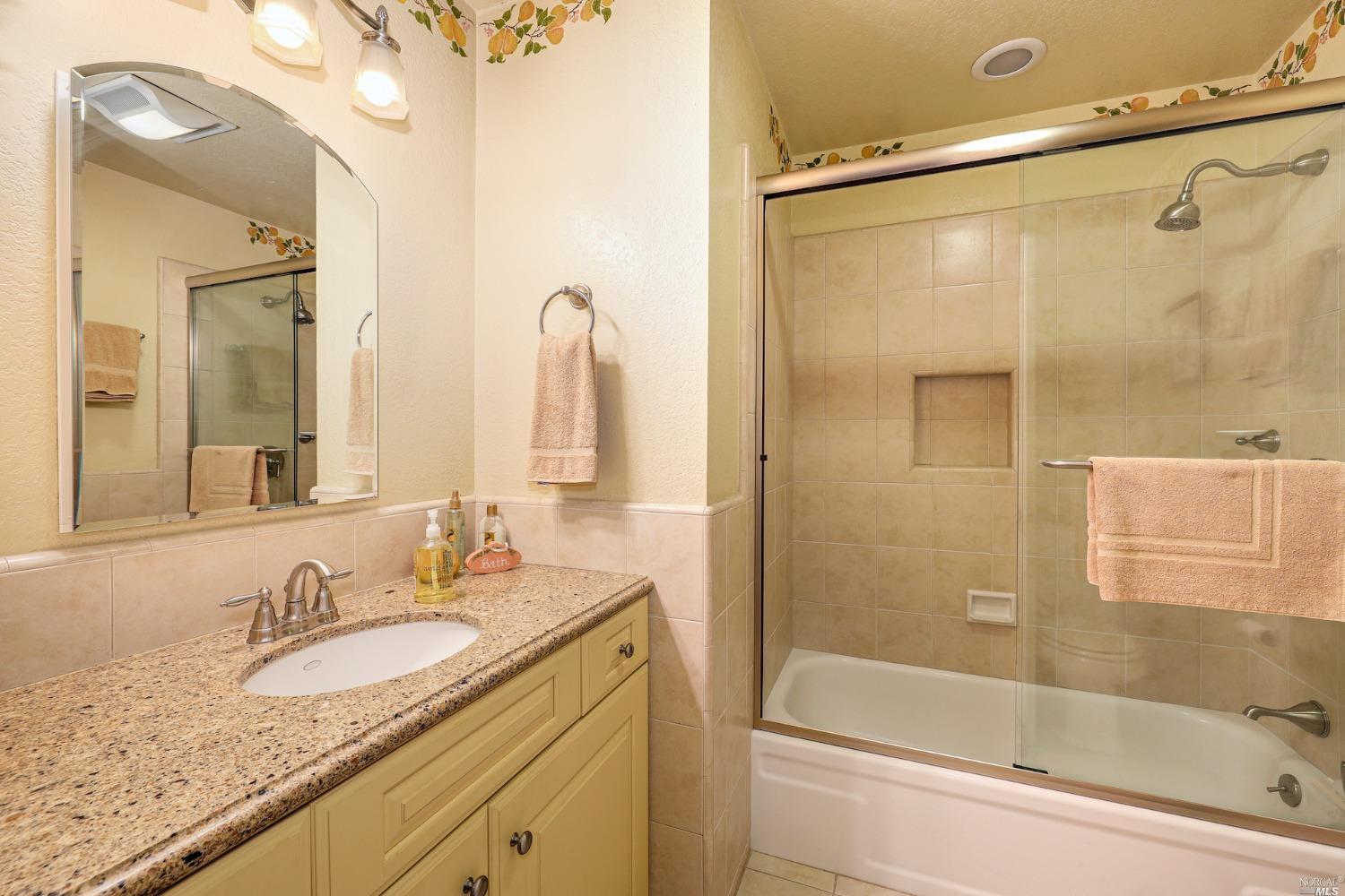 1454 Olivet Road Santa Rosa, CA 95401 - Photo 15 of 30 a bathroom with a granite countertop sink mirror toilet and bathtub