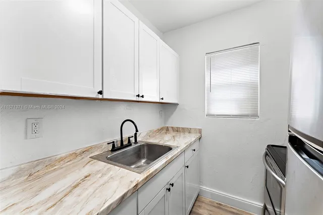 a kitchen with stainless steel appliances granite countertop a sink and a white cabinets