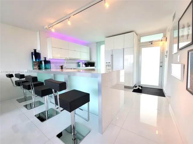 a kitchen with stainless steel appliances kitchen island granite countertop a refrigerator and cabinets