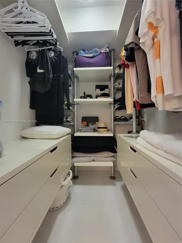 a view of walk in closet with clothes and shoes