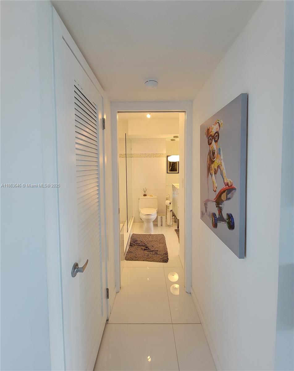 1670 Lincoln Court, Unit 3B Miami Beach, FL 33139 - Photo 10 of 13 a hallway with a dining table and a mirror