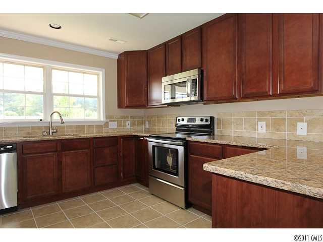 1740 Dunlap Roddey Road Rock Hill, SC 29730 - Photo 6 of 16 a kitchen with granite countertop wooden cabinets a stove top oven