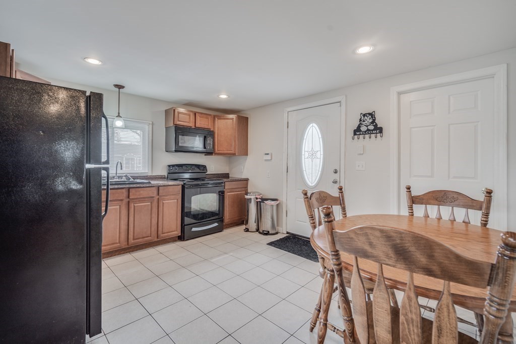4 Jean Drive Springfield, MA 01104 - Photo 16 of 26 a kitchen with stainless steel appliances granite countertop a stove a sink a microwave a dining table and chairs