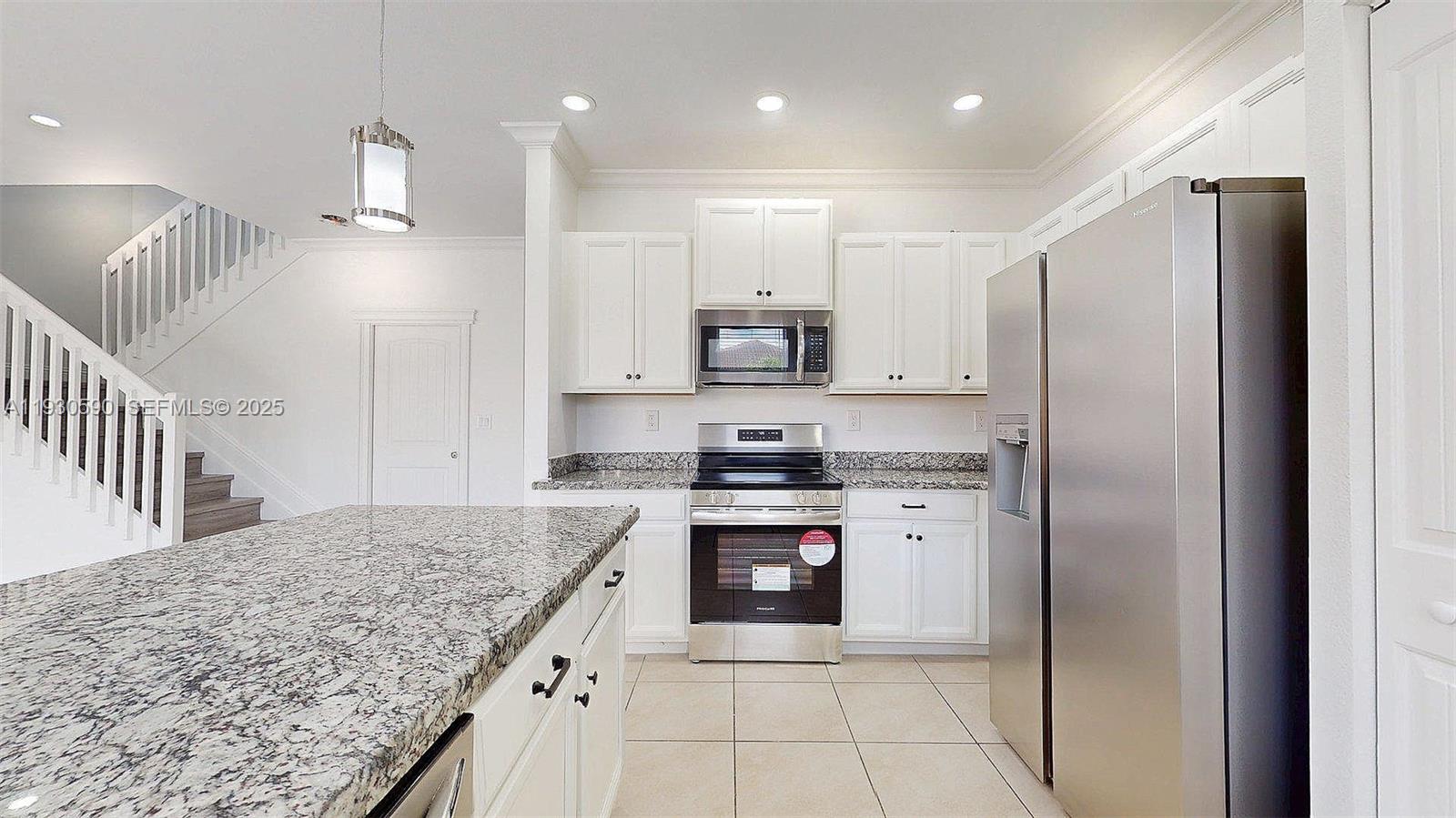 25324 Southwest 119th Avenue Homestead, FL 33032 - Photo 12 of 41 a kitchen with kitchen island granite countertop a stove a sink and a refrigerator