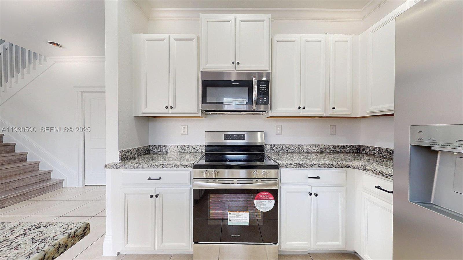 25324 Southwest 119th Avenue Homestead, FL 33032 - Photo 13 of 41 a kitchen with stainless steel appliances granite countertop a stove and a white cabinets