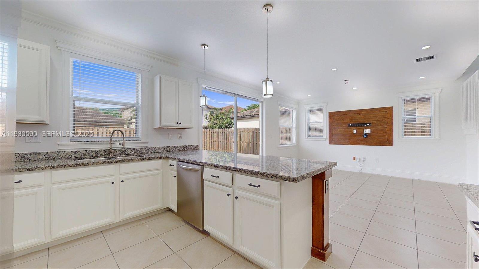 25324 Southwest 119th Avenue Homestead, FL 33032 - Photo 14 of 41 a kitchen with granite countertop a sink and white cabinets
