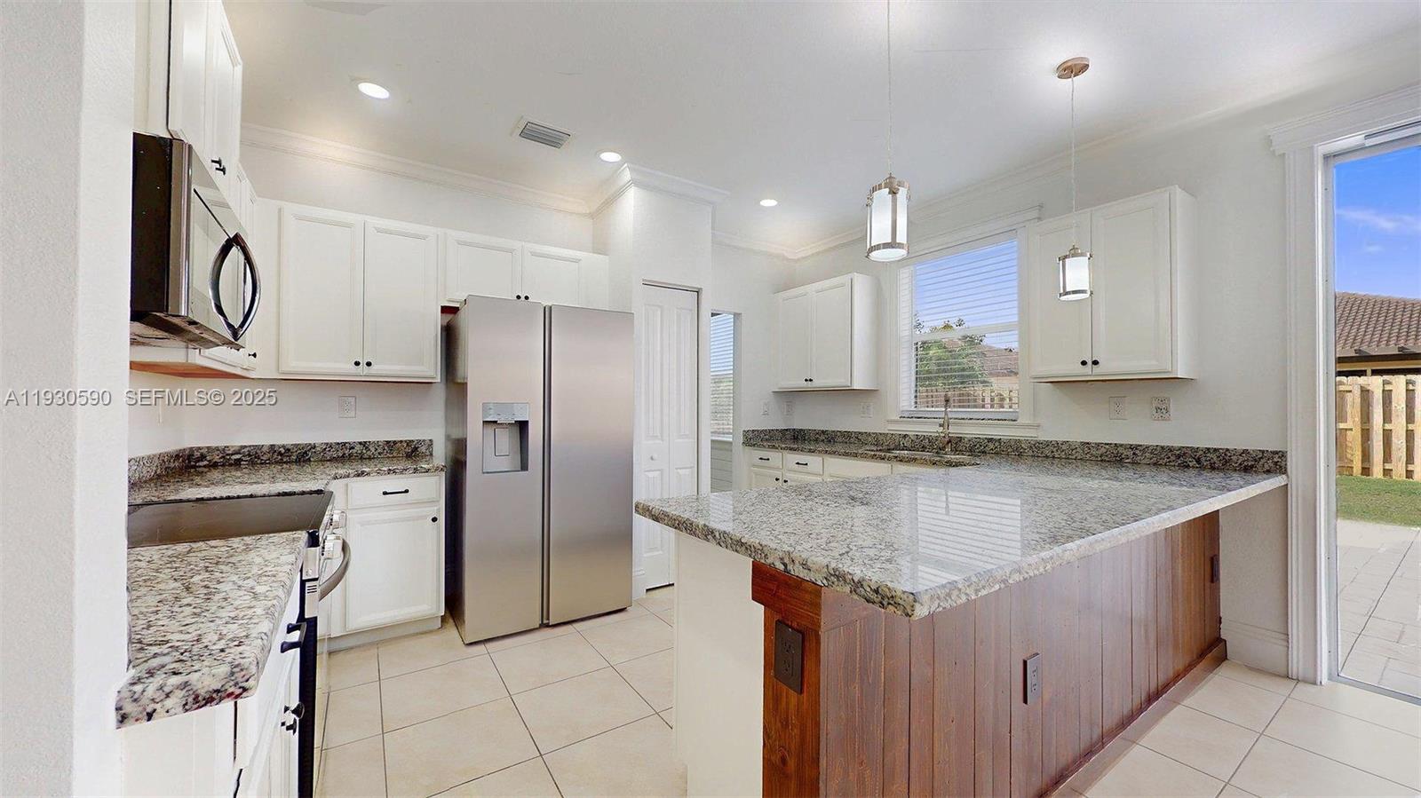25324 Southwest 119th Avenue Homestead, FL 33032 - Photo 16 of 41 a kitchen with stainless steel appliances granite countertop a refrigerator a sink and a stove