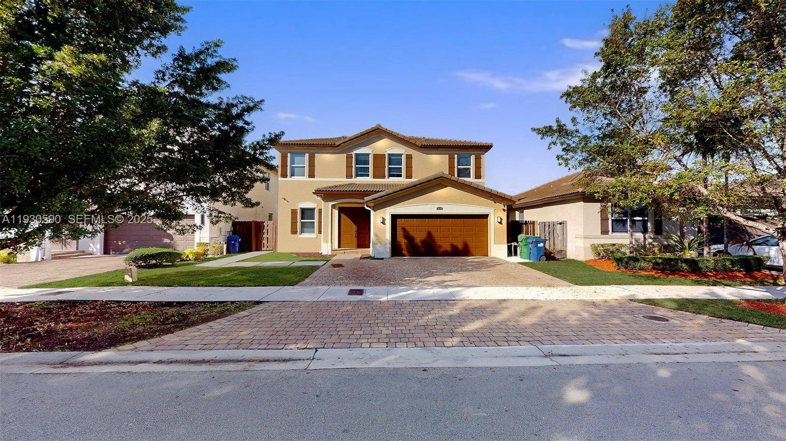 25324 Southwest 119th Avenue Homestead, FL 33032 - Photo 2 of 41 a front view of a house with a yard and garage