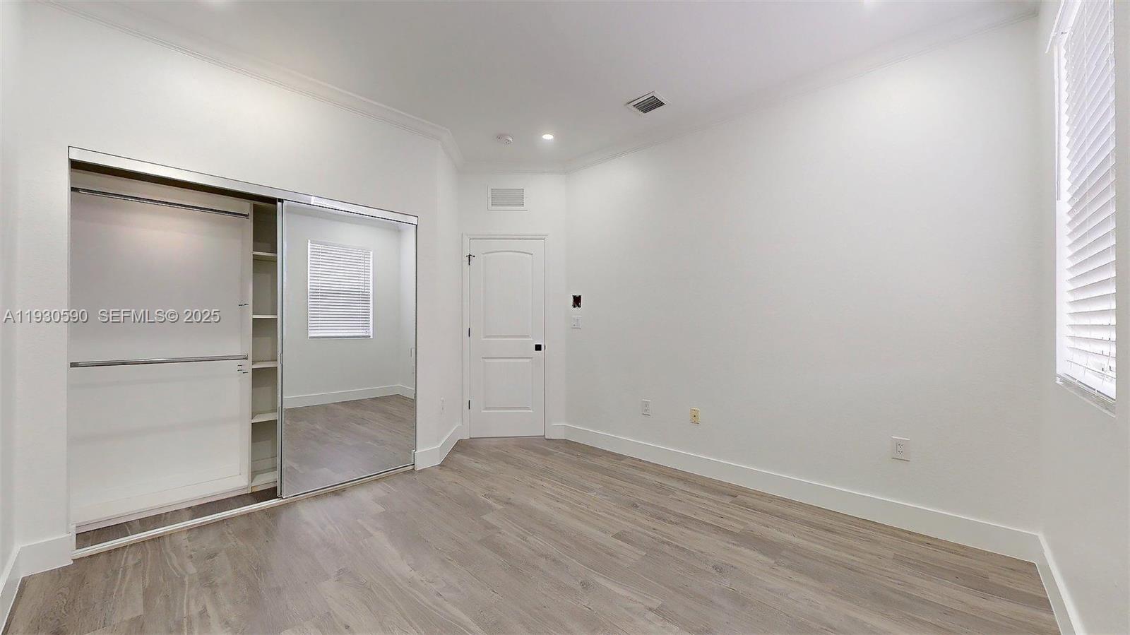 25324 Southwest 119th Avenue Homestead, FL 33032 - Photo 27 of 41 an empty room with wooden floor closet and windows