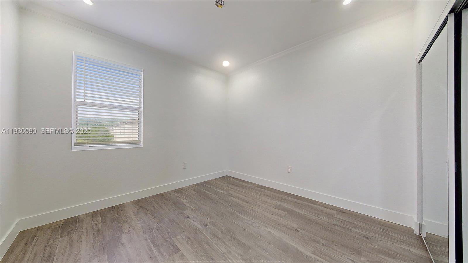 25324 Southwest 119th Avenue Homestead, FL 33032 - Photo 28 of 41 an empty room with wooden floor and windows