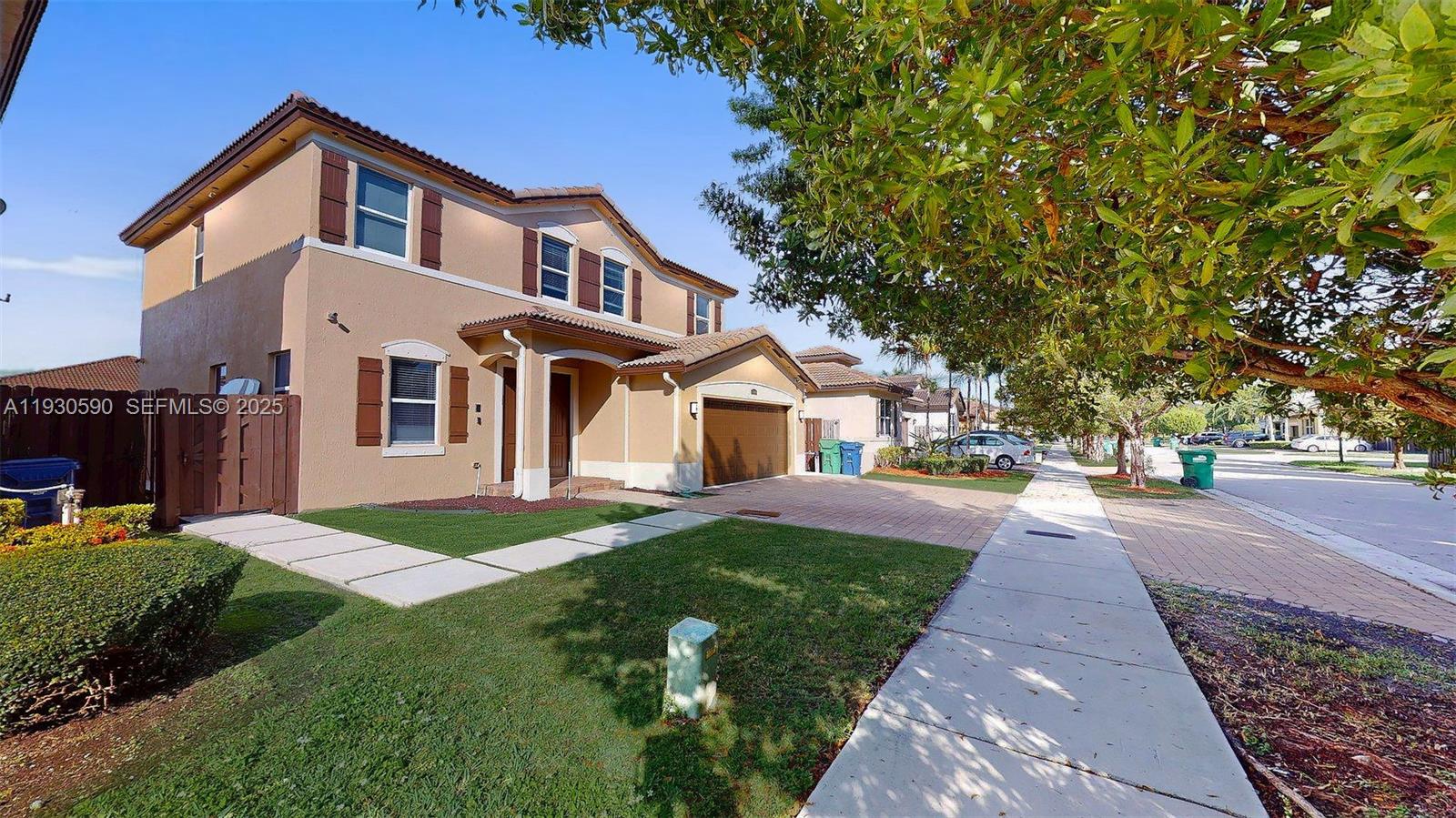 25324 Southwest 119th Avenue Homestead, FL 33032 - Photo 3 of 41 a front view of a house with a yard and garage