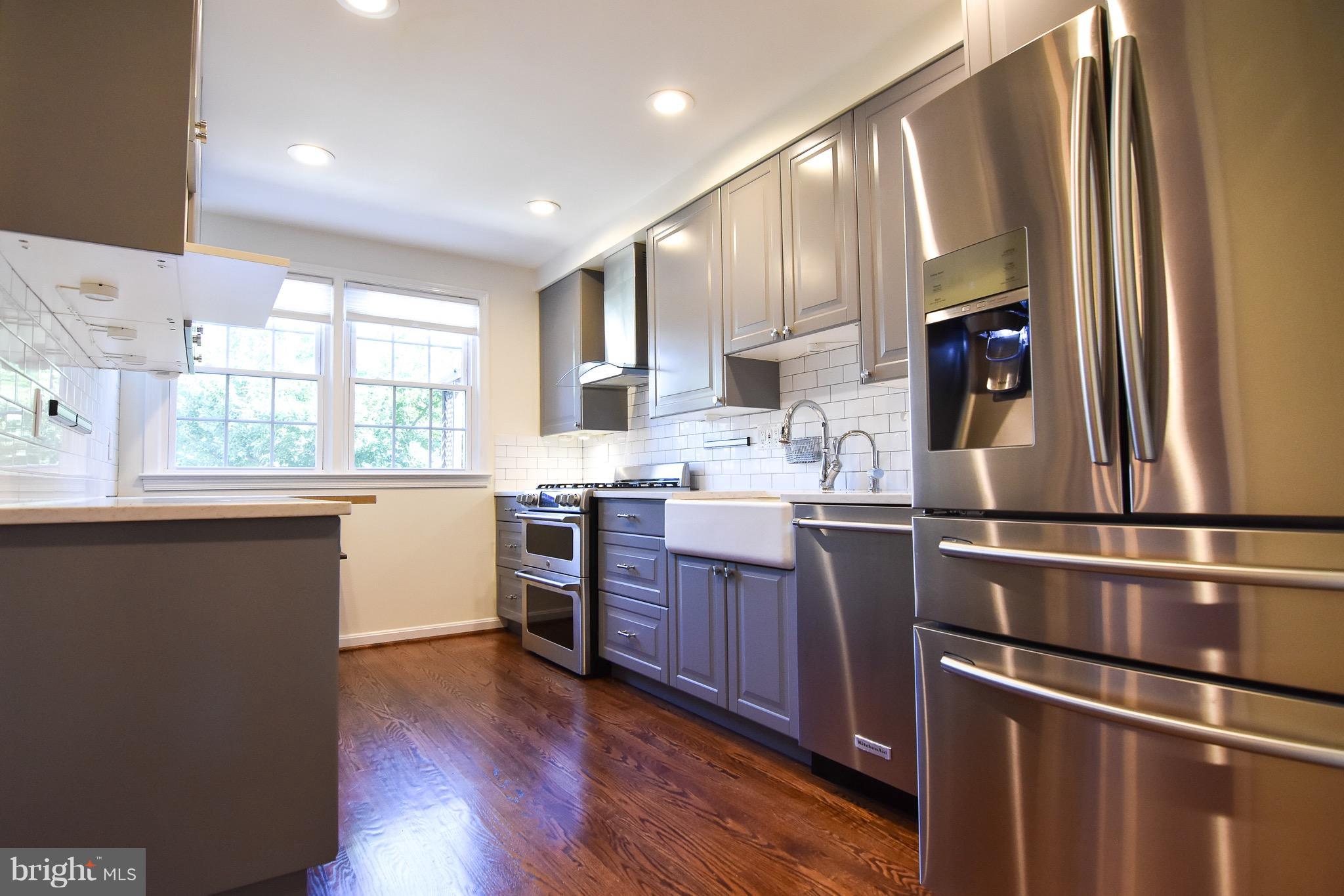 3302 Spring Lane Falls Church, VA 22041 - Photo 7 of 30 a kitchen with a sink wooden floor and black appliances